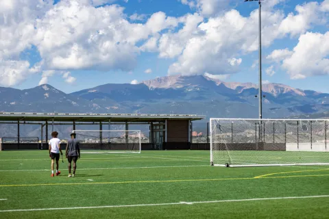 students walking on Alpine Field, facing the mountains
